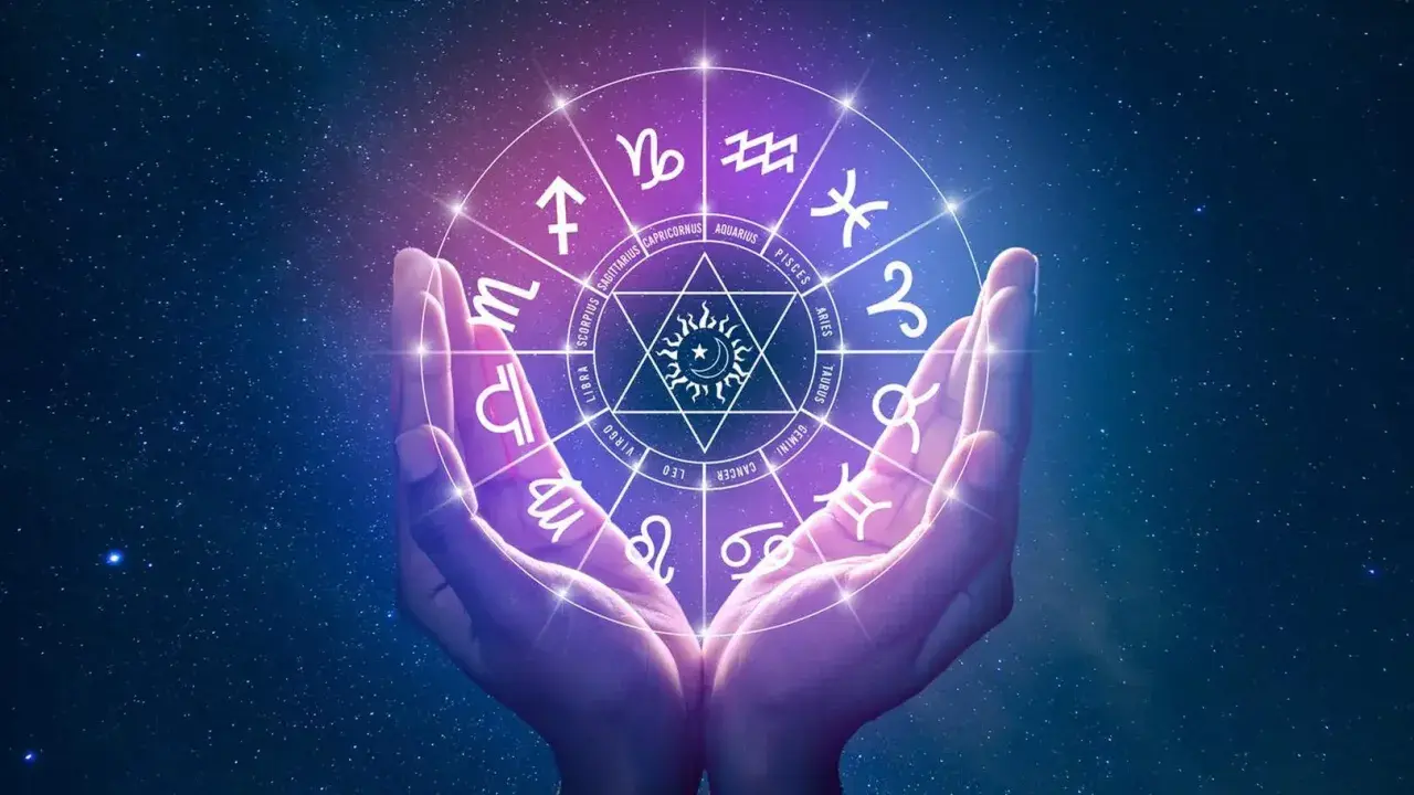 Dłonie trzymają koło zodiaku, gdzie saturn w 5 domu symbolizuje kreatywność i radość.