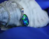Błękitny opal w wisiorku, mieniący się zielenią i niebieskim. Jego właściwości uspokajają i dodają pewności siebie.