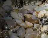 Mnóstwo gładkich, polerowanych minerałów, kamieni szlachetnych i skał w odcieniach bieli, szarości i brązu, tworzących bogactwo natury.