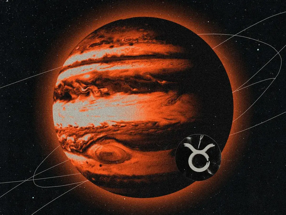 Pomarańczowy Jowisz w kosmosie, obok symbol zodiaku Byk.