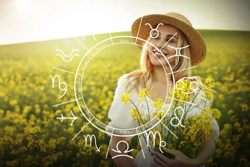 Uśmiechnięta blondynka w słomkowym kapeluszu, z bukietem żółtych kwiatów, na tle kwitnącego pola. Na obrazie widoczny jest okrąg zodiaku, gdzie Wenus w 10 domu symbolizuje publiczne uznanie i karierę.